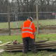 Knight Fencing team member working in waterlogged, muddy ground conditions during a winter timber fencing installation