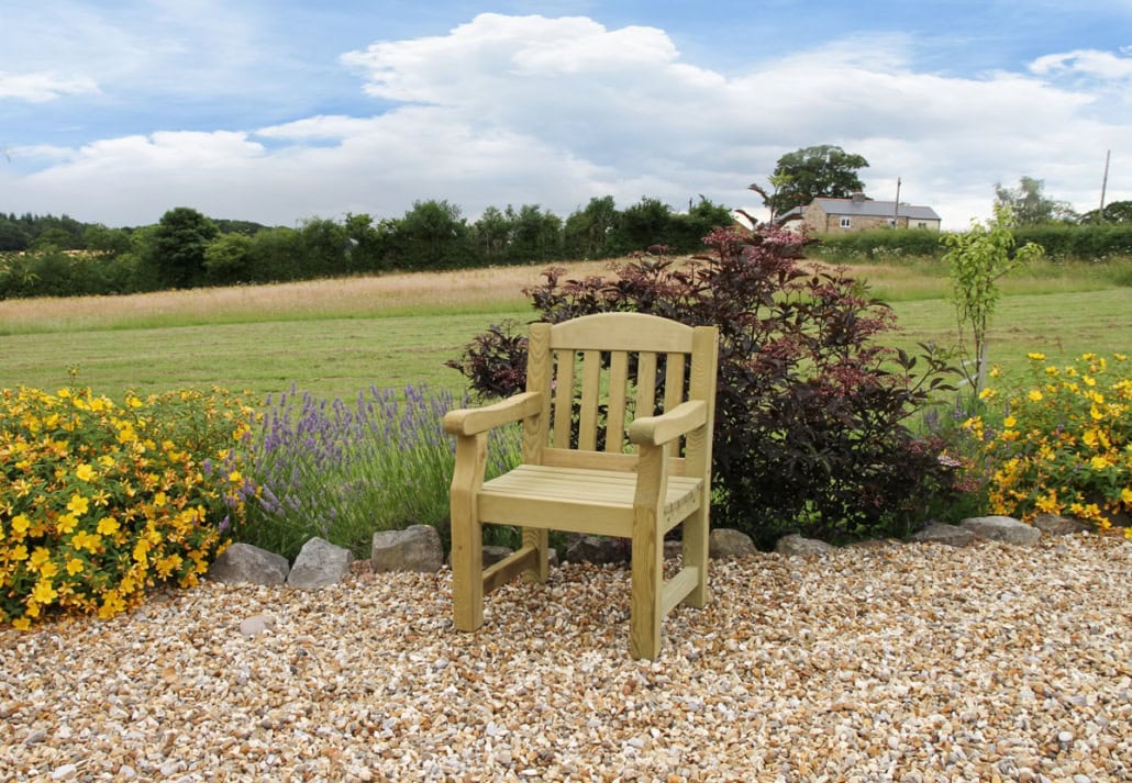 Wooden Garden Chair 1 Garden chair in a landscaped outdoor setting with flowers and greenery.
