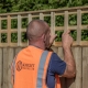 a man fitting trellis panel on a fence