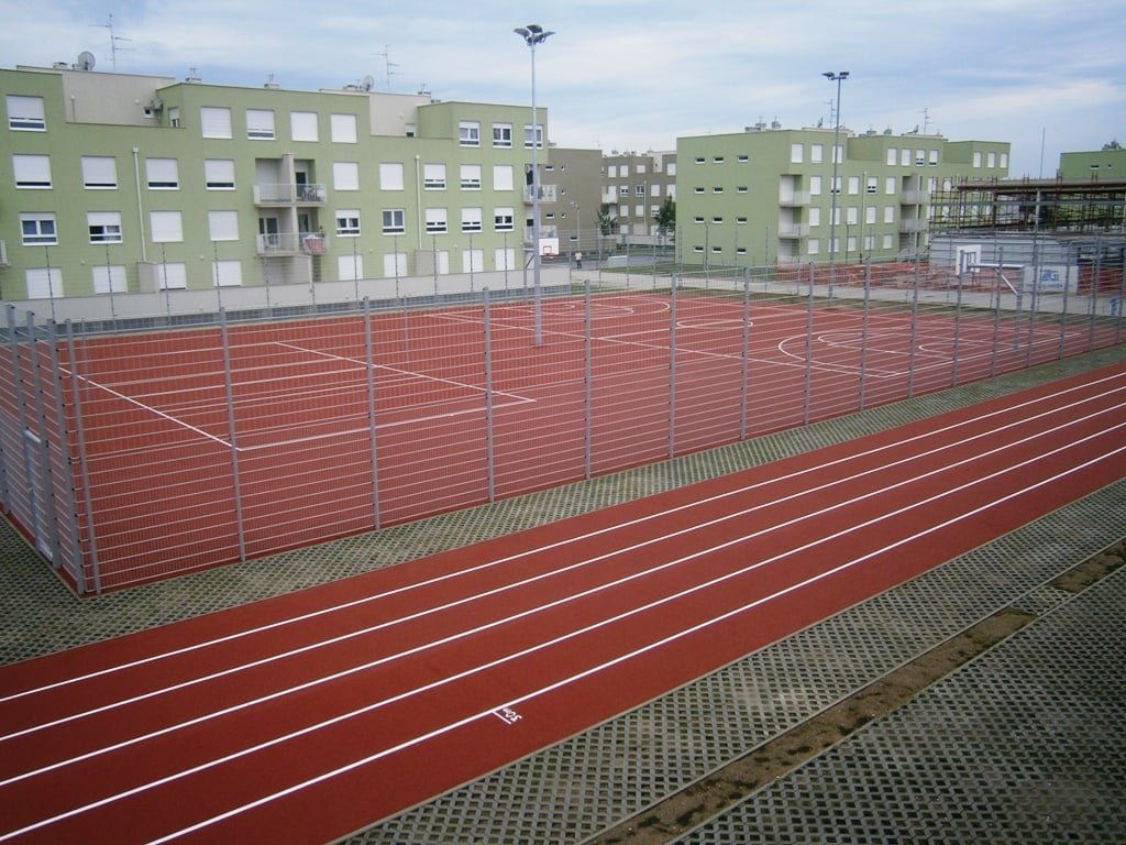 A photo of a fence around a ball court