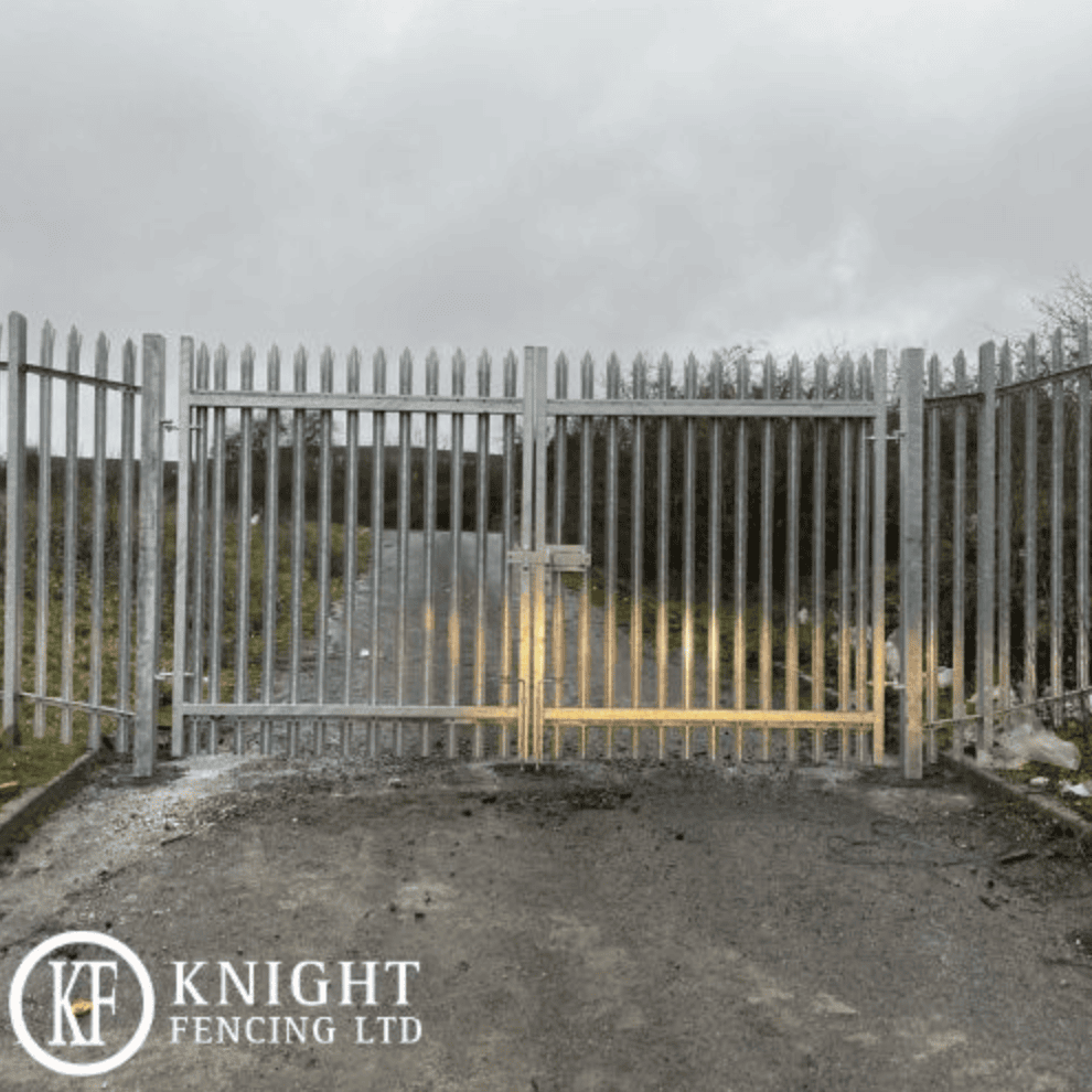 Galvanised steel palisade security gate installed on an industrial access road.