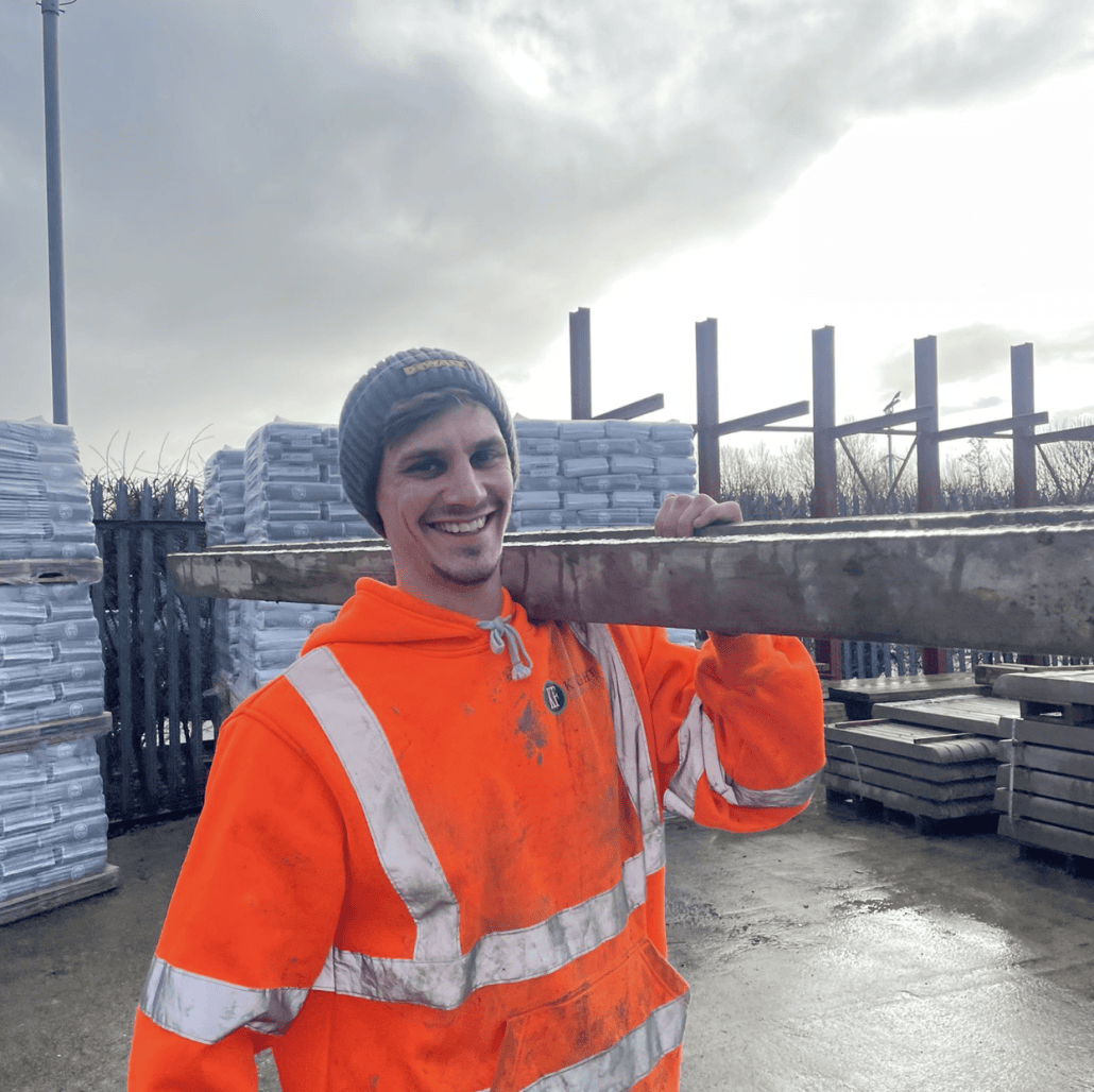 Knight Fencing apprentice George carrying a concrete post during on-the-job training