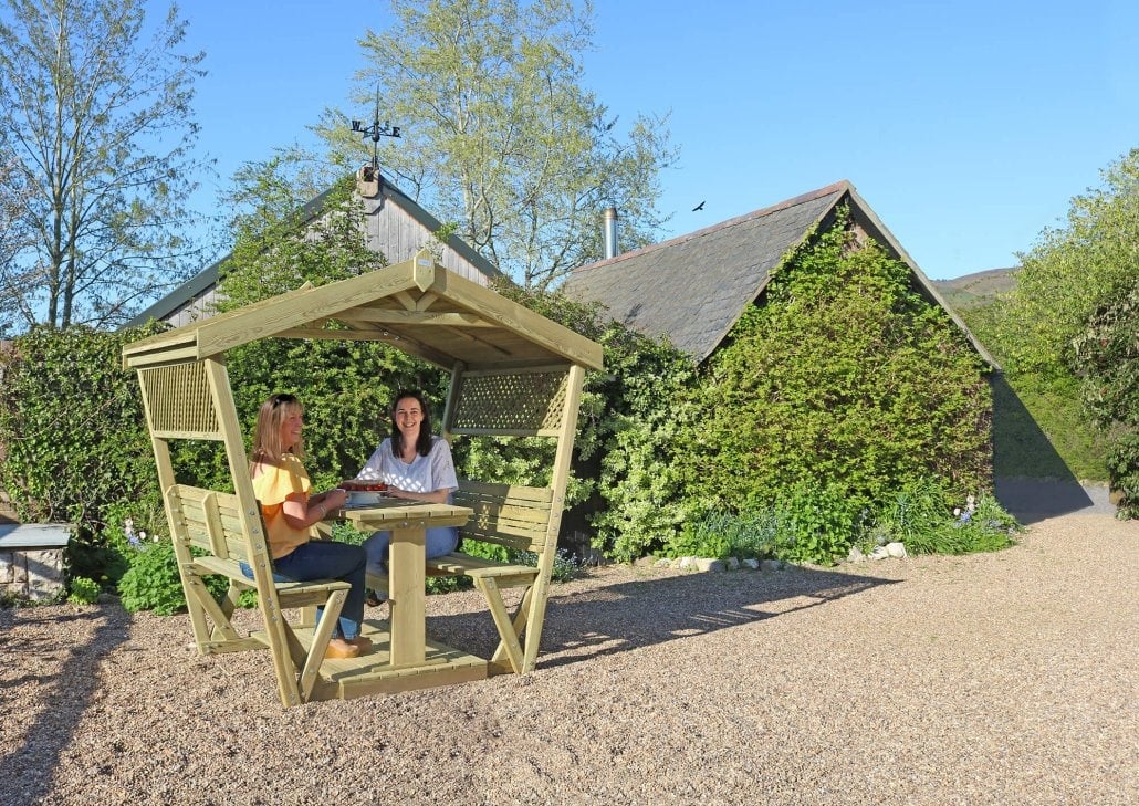 Stirling Arbour 6 Women sitting in Stirling wooden garden gazebo with table and benches