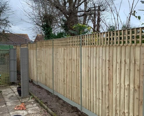 Trellis on closeboard fence panel with concrete gravel board