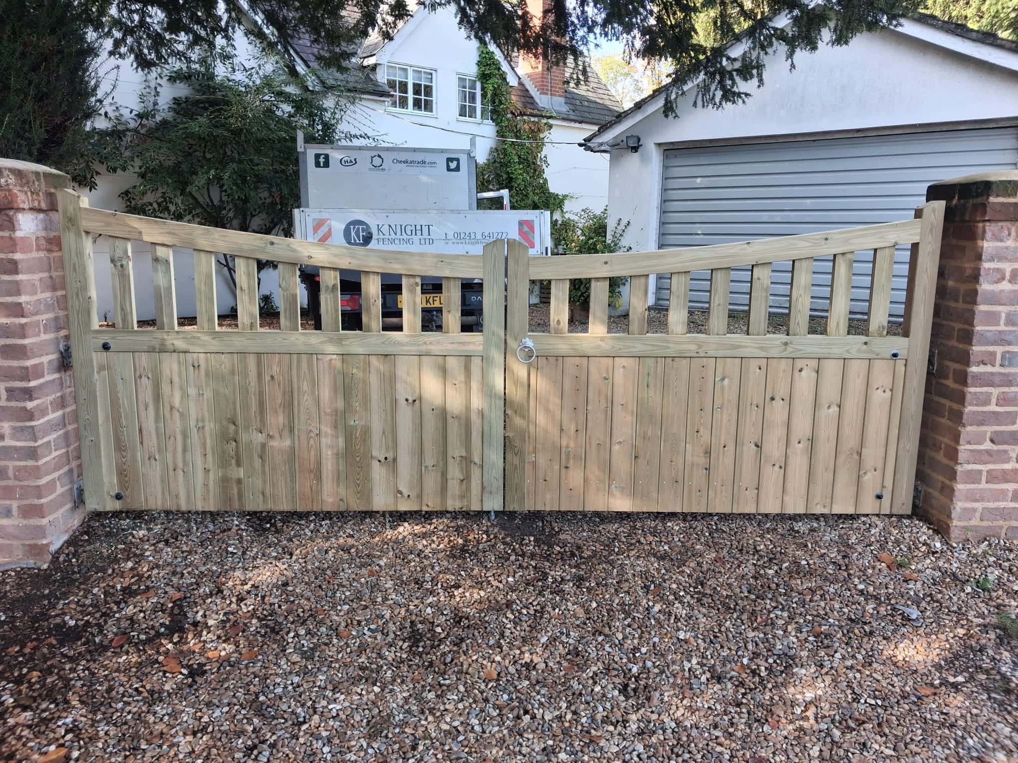 Bespoke Highleigh driveway gates in light softwood, providing an attractive and unique entrance on a gravel driveway