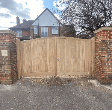 Wooden Gate Installation for Dell Quay Gates Light timber Dell Quay driveway gates installed between brick pillars, providing high durability and total property privacy