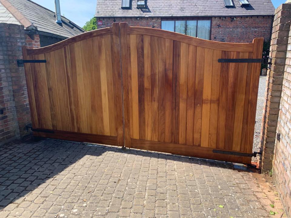 Elegant Wooden Garden Gate Richly stained hardwood Dell Quay entrance gates by Knight Fencing, featuring a stylish decorative curved top for a premium look