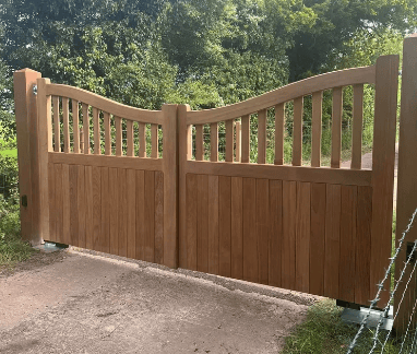 Premium hardwood Highleigh entrance gates with a distinctive scooped-top panel, set on a private driveway.