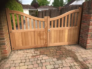 highleigh-hardwood-driveway-gates-scooped-top Premium hardwood Highleigh entrance gates with a distinctive scooped-top panel, set on a private driveway