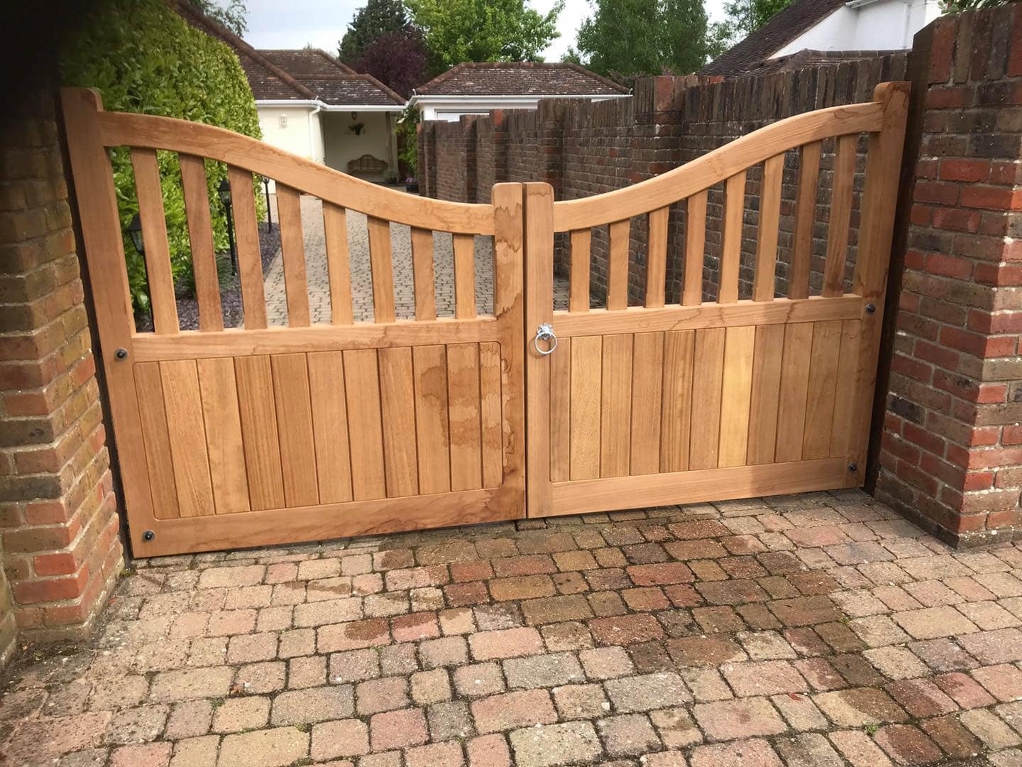 Premium hardwood Highleigh entrance gates with a distinctive scooped-top panel, set on a private driveway