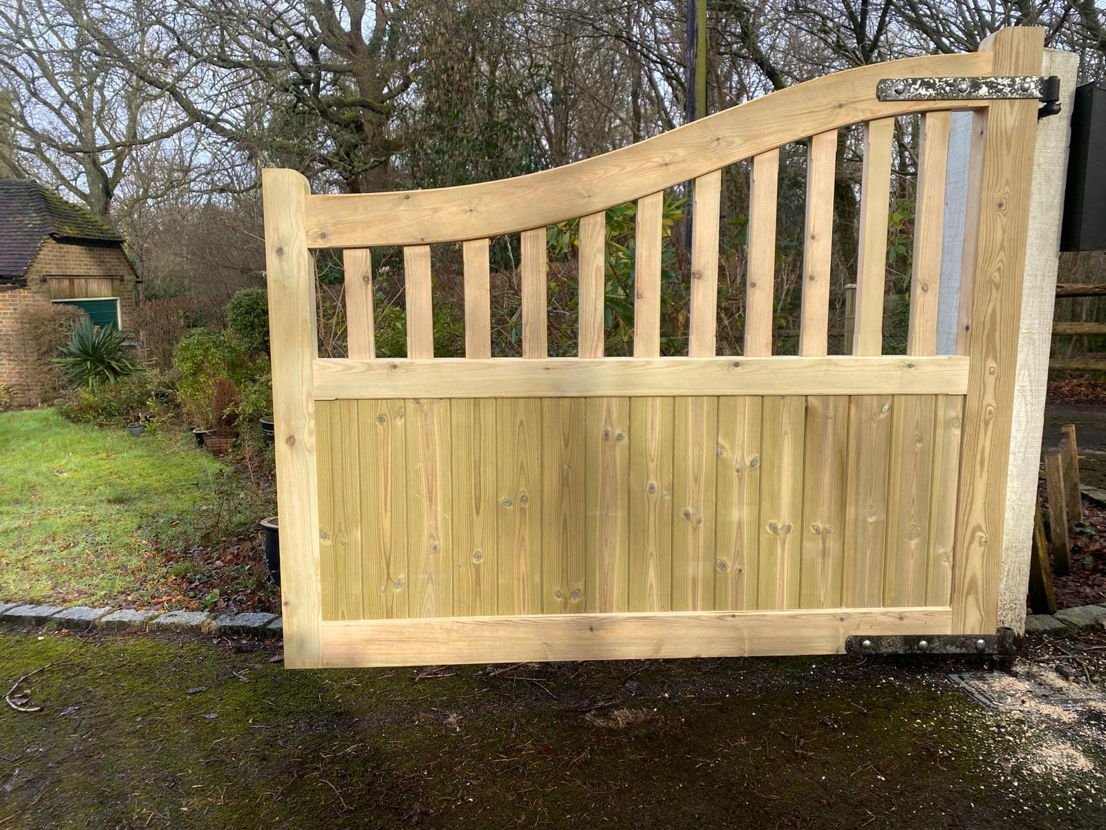 Single leaf of a Highleigh softwood gate showing the unique scooped-top detail and vertical timber base construction.