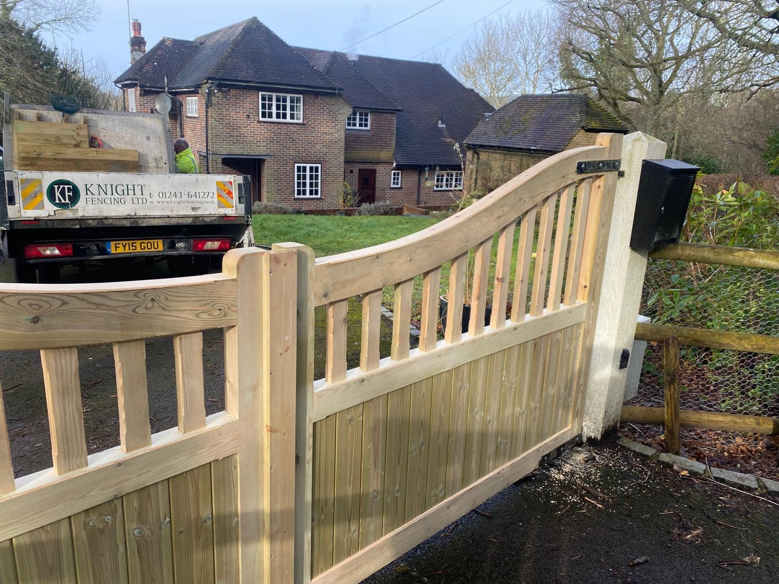 Bespoke Highleigh wooden entrance gates during installation by the Knight Fencing team at a residential property