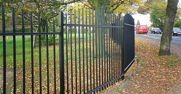 A photo of a vertical bar railing fence in a park setting